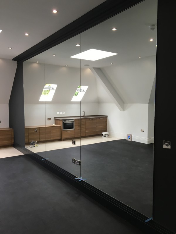 Frameless glass partition in loft conversion by Bracknell glaziers